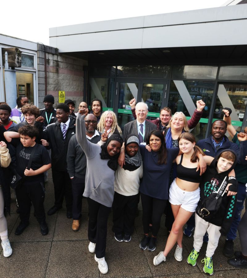 A photograph of a group of young people and councillors celebrating in front of the Blackbird Leys Youth Centre