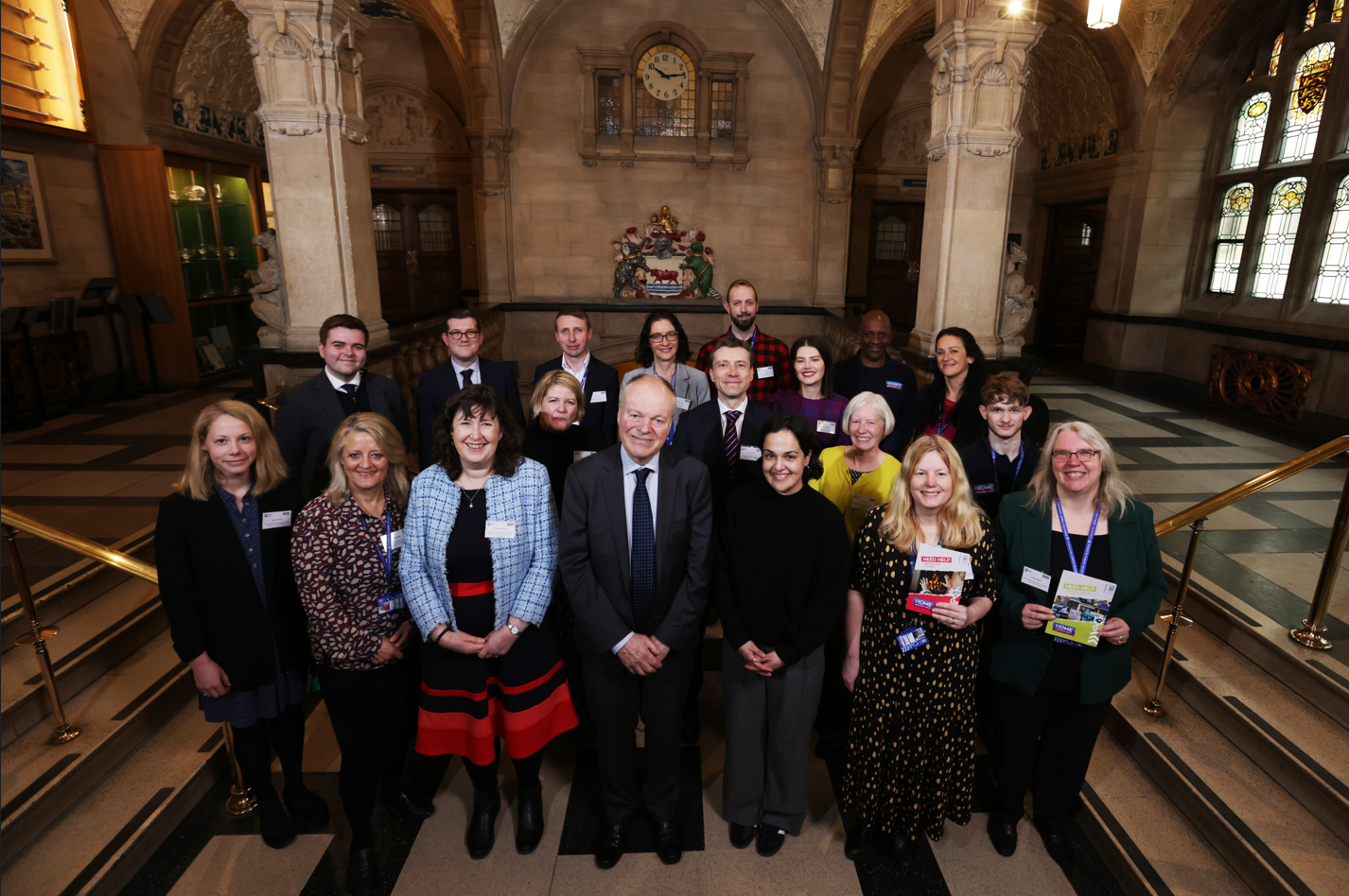 A group of individuals, including MPs and Oxford City Council staff, stand in the grand hall of Oxford Town Hall.