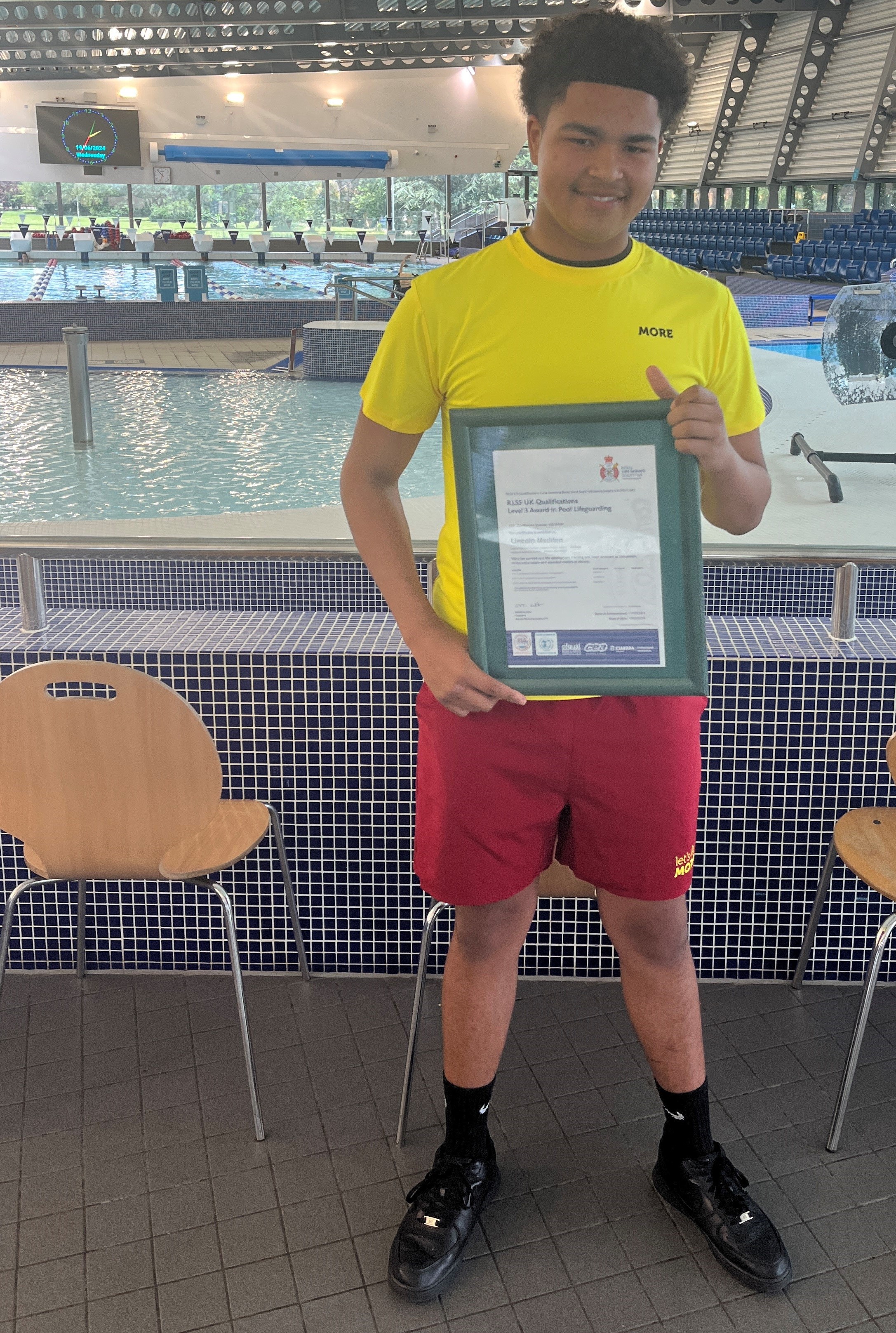lifeguard holding certificate at Leys pool.